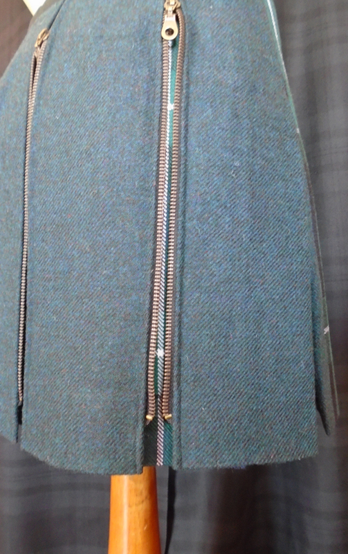 Sur cette jupe zippée, c'est le tweed qui est dessus et le tartan à l'intérieur des plis